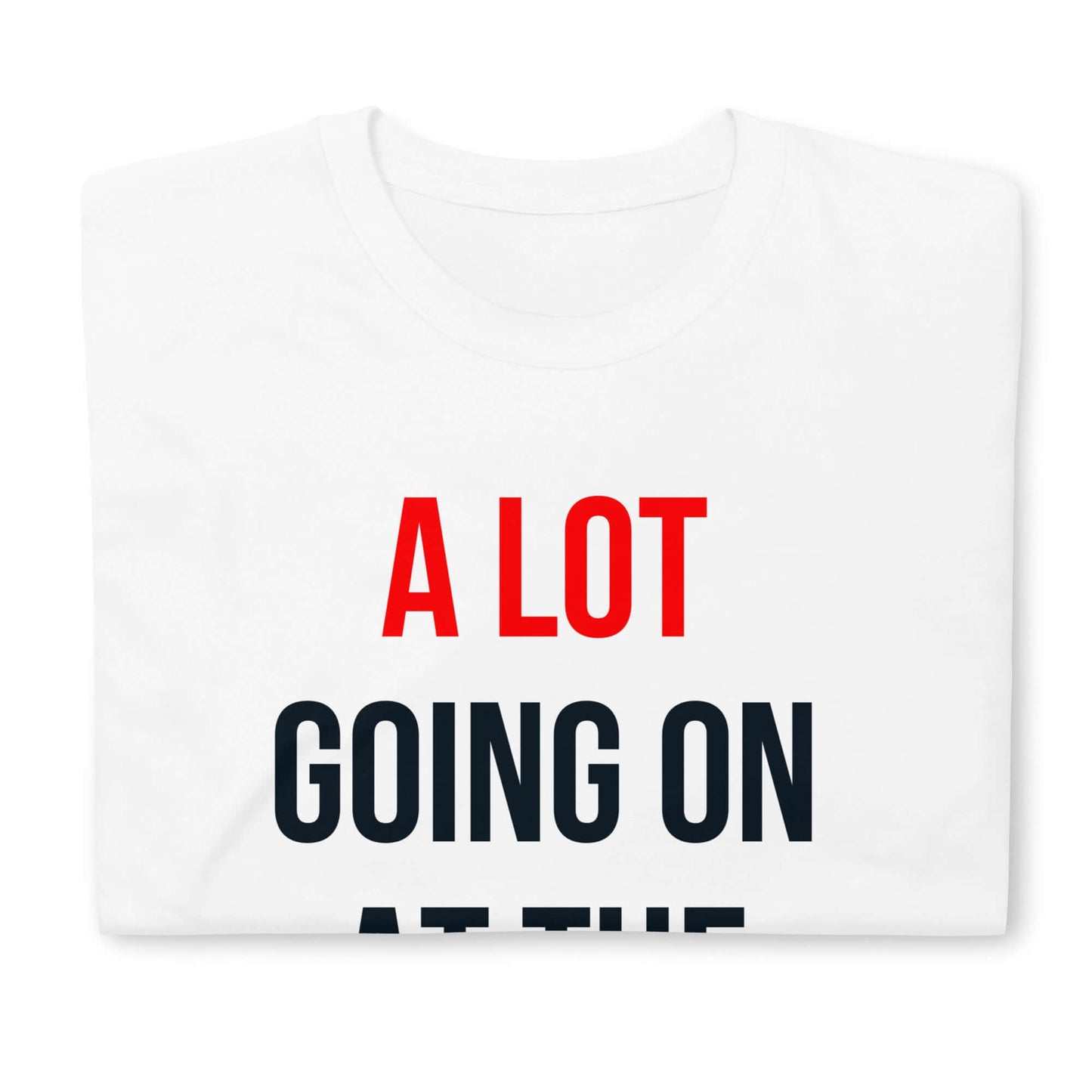 Folded white t-shirt with text "A Lot Going On At The Moment" in red and black letters on the front.