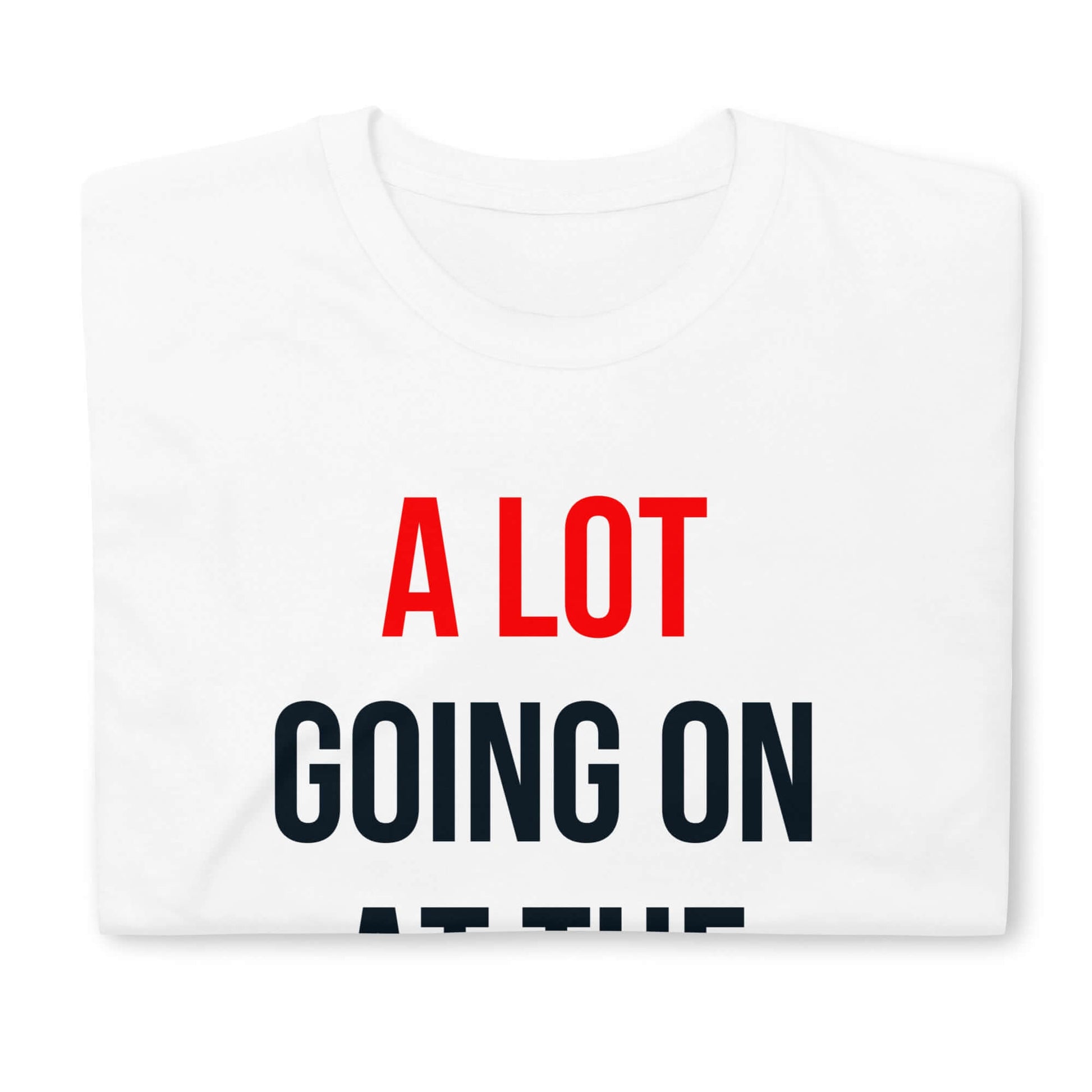 Folded white t-shirt with text "A Lot Going On At The Moment" in red and black letters on the front.